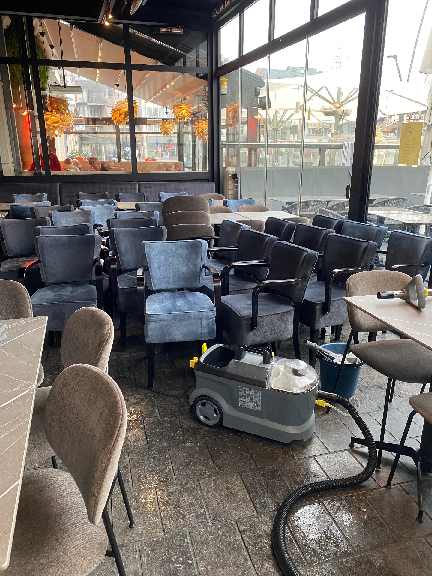Injectie-extractiemachine tussen de stoelen in een restaurant met glazen gevel